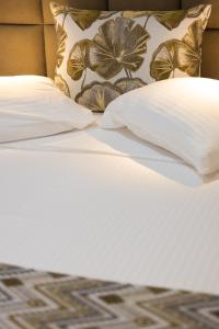 a bed with white sheets and pillows on it at Haraki Village in Haraki