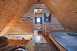 a room with a bed in a wooden cabin at Domek Nad Sadem in Łącko