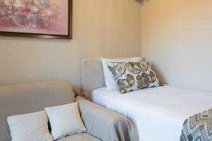 a room with a bed and a couch and a pillow at Haraki Village in Haraki