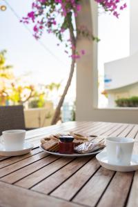 two cups and a plate of food on a wooden table at Haraki Village in Haraki