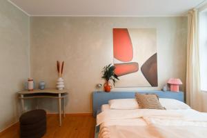 a bedroom with a bed and a painting on the wall at Loft Apartment in Hinterhof-Remise nähe Karl-Heine in Leipzig