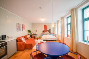 a living room with a table and a couch at Loft Apartment in Hinterhof-Remise nähe Karl-Heine in Leipzig +4 photos