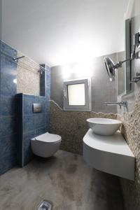 a bathroom with a toilet and a sink and a mirror at Haraki Village in Haraki