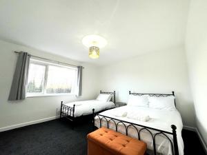 Un dormitorio con dos camas y una ventana. en New Southampton Central House - Parking, 6 Beds, Sleeps 9 - City Centre l Cruise Terminal l Great for Contractors, Friends & Families, en Southampton