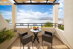 a balcony with a table and chairs and a view of the water at Haraki Village in Haraki
