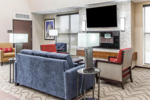 sala de estar con sofá y TV en Comfort Suites West Omaha, en Omaha