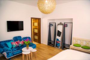 Boutique Hotel Frieden في فايدن: غرفة معيشة مع أريكة زرقاء وطاولة