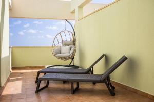 una silla sentada en una sala con un columpio en CASA DOBLE - penthouse, pool, priv parking, fibre net, spacious terrace, en San Miguel de Abona 32 fotos más