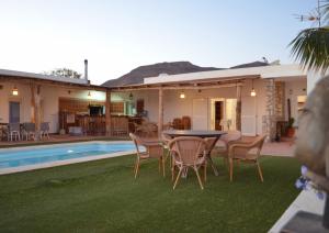 a patio with a table and chairs next to a pool at Villa Mónica by Mirador de Sotavento Apartments in Cardón