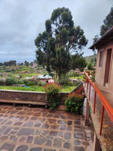 vista su un giardino con un albero e una casa di Home in Taquile - Q'uñi wasi a Huillanopampa