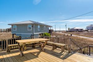 eine Holzterrasse mit einem Picknicktisch und einem Haus in der Unterkunft You Are My Sunshine in Dauphin Island