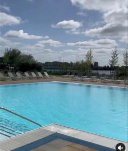 ein großer Pool mit Stühlen und blauem Wasser in der Unterkunft Rachel Retreat Caravan Kingfisher Court Tattershall Lake in Tattershall