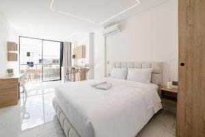 麦德林Foret Lofts的一间白色卧室,配有一张大床和一个厨房