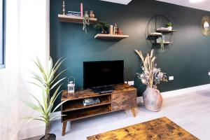 a living room with a television on a wooden entertainment center at Premium CITY Apartment in Hemel Hempstead