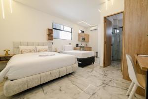 a hotel room with two beds and a bathroom at Foret Lofts in Medellín