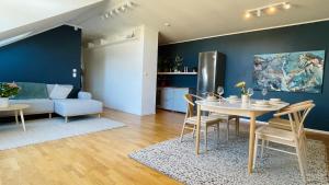 a kitchen and living room with a table and chairs at Penthouse apartment balcony,parking and 2 bedrooms in Oslo