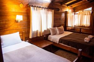 1 Schlafzimmer mit 2 Betten in einer Holzhütte in der Unterkunft Tree House Lodge in Machu Picchu