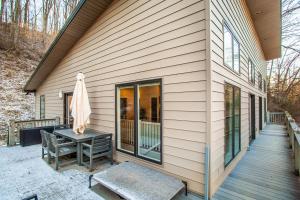 诺克斯维尔Knoxville Charm Cottage 5 miles to Market Square的房子边有桌子的屏蔽门廊