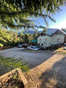 a house with cars parked in front of it at B&B Don Ciro in Villa La Angostura