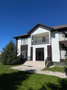 a large white house with a large driveway at Family cottage in Bosteri