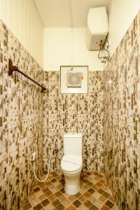 Un baño con inodoro en una habitación con azulejos. en Villa Grand Mellow, en Nuwara Eliya