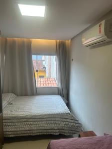 a small room with a bed and a window at Comfortable home for COP-30 in Belém