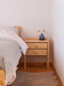 a bed with a wooden nightstand with a plant on it at Dom w górach Saganówka Beskidy in Międzybrodzie Bialskie +108 photos