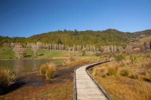 a wooden boardwalk next to a body of water at Okareka Escape in Rotorua