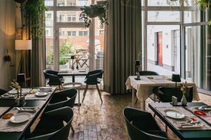 a restaurant with tables and chairs and large windows at The Layhead B&B in Lübeck