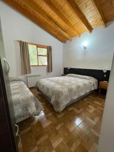 a bedroom with two beds and a wooden floor at B&B Don Ciro in Villa La Angostura +11 photos