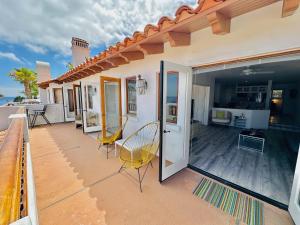 a balcony of a house with chairs and a table at Bright Avalon Villa W Ocean Views & Hot Tub in Avalon +21 photos