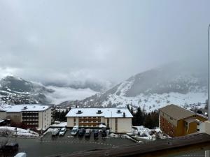 a view of a snowy mountain with buildings and cars at Homency - Residence Signal C32 in L'Alpe-d'Huez
