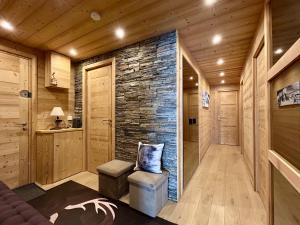 a sauna with a stone wall and a bench and stool at Homency - Residence Signal C32 in L'Alpe-d'Huez