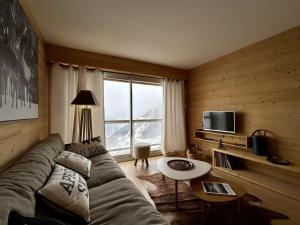 a living room with a couch and a large window at Homency - Residence Signal C32 in L'Alpe-d'Huez