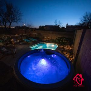 a large blue pool in a yard at night at Gusto Retreat Modern Serenity - An Irvie Home in Albuquerque