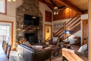 - un salon avec des canapés et une cheminée en pierre dans l'établissement Land Harbor Lodge, à Newland