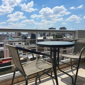 une table et des chaises sur un balcon avec vue dans l'établissement Recoleta a 5 cuadras de El Ateneo, à Buenos Aires