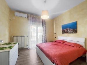 a bedroom with a bed with a red blanket at House Rene in Agerola