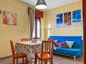 a living room with a blue couch and a table and chairs at House Rene in Agerola