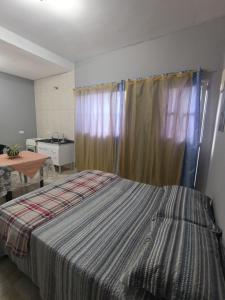 a bedroom with a bed and a table and a window at Studio _ Santana de Parnaíba SP in Santana de Parnaíba