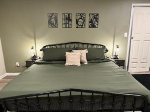 una camera da letto con un letto grande con due cuscini di King Suite - Private Entrance - Hot Tub - Game Room a Jonesboro