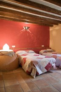 1 dormitorio con 2 camas y pared roja en Rural Montes Málaga: Cortijo La Palma, en Málaga