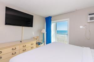 - une chambre avec un lit et une grande fenêtre donnant sur l'océan dans l'établissement Breath-taking Remodeled Oceanfront Studio! Sea Mist 20307, à Myrtle Beach