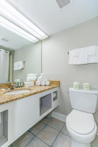 une salle de bain avec toilettes, lavabo et miroir dans l'établissement Breath-taking Remodeled Oceanfront Studio! Sea Mist 20307, à Myrtle Beach