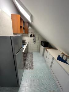 a small kitchen with a refrigerator and white cabinets at La Casetta Dei Pescatori in Montesilvano
