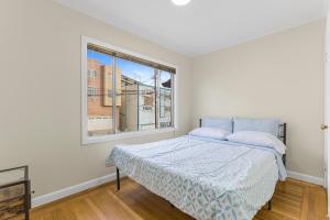 a white bedroom with a bed and a window at 3 Bedroom 2 Bathroom House, Walkable to BART, Free Parking, Views in Daly City