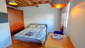 ein kleines Schlafzimmer mit einem Bett und einem Tisch in der Unterkunft 012 Grand studio at quartier latin in Paris