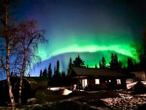 基律纳LAKESIDE AURORA CABINS的天空中北灯在小屋上的图像