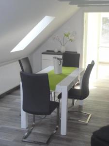 une salle à manger avec une table et des chaises blanches dans l'établissement Groß Kölzig - Moderne Ferienwohnung in ländlicher Idylle, à Neiße-Malxetal