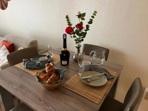 a dining room table with a bottle of wine and a table with a bottle at Duinhelm Vakantiestudio Mariakerke - A cosy place by the sea in Ostend
